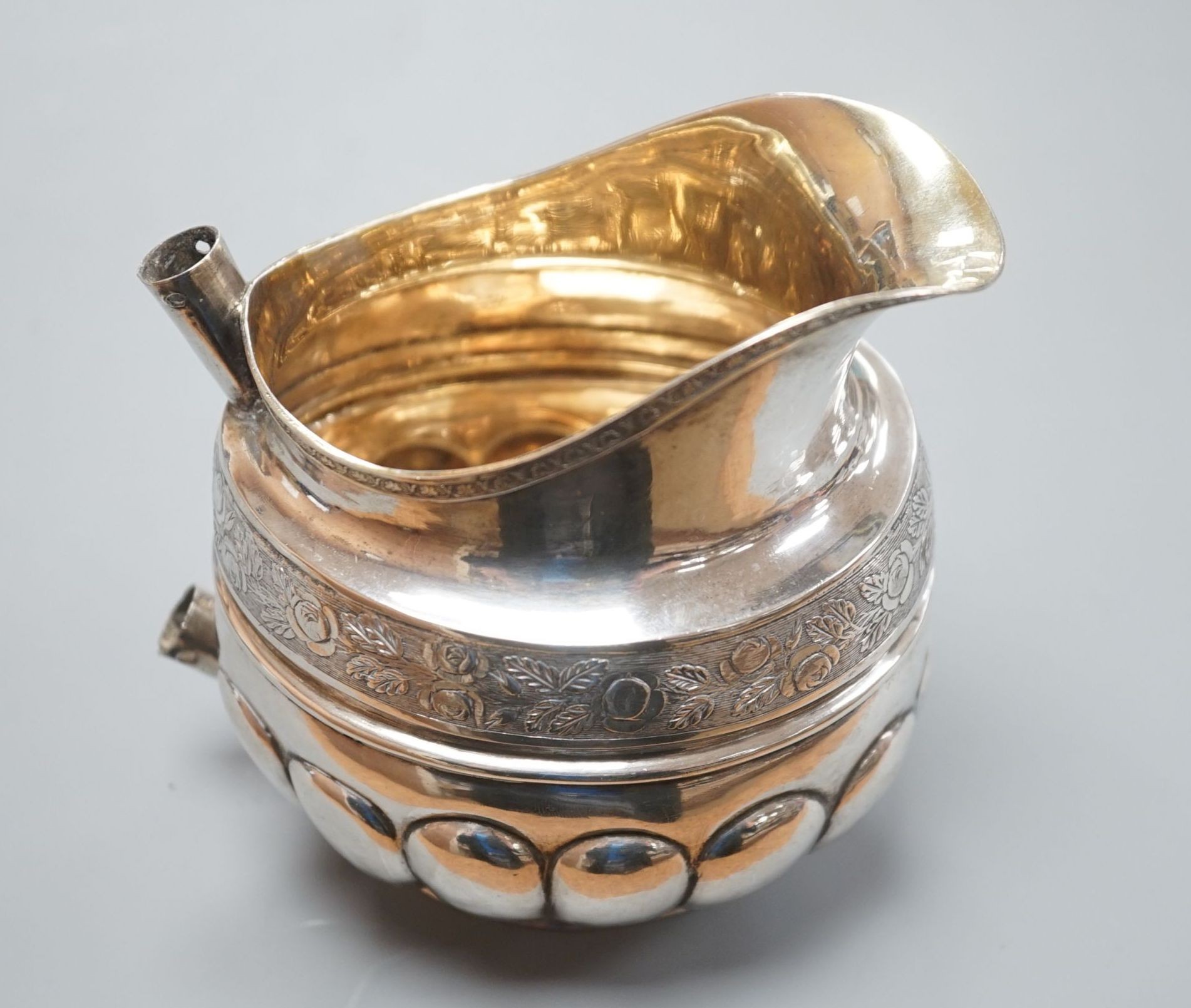 A 19th century Russian 84 zolotnik embossed cream jug, assay master, Michael Karpinsky, 1829, master, Fredrik Lonnqvist, with wooden handle (rivets missing), height 11.2cm, 6oz.